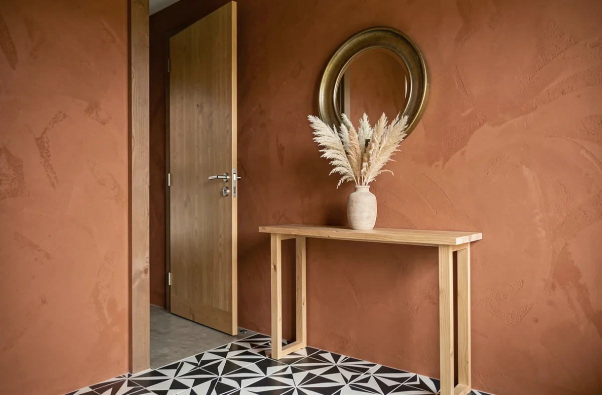 Entrée moderne avec peinture terracotta, miroir en laiton vieilli et sol en carreaux géométriques